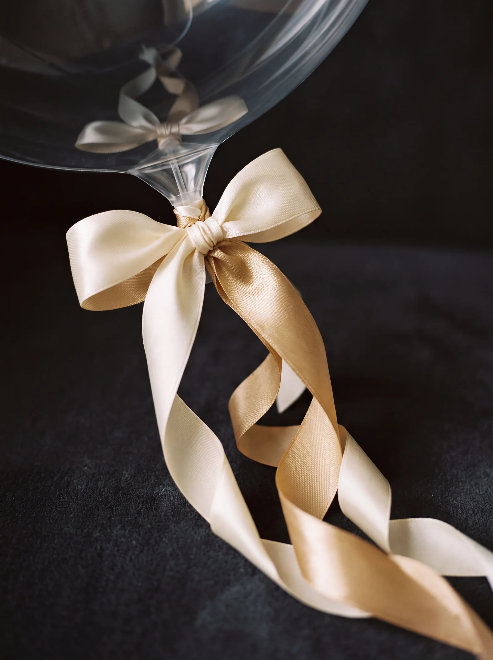 Close up of ivory and gold satin ribbon on a clear bubble balloon