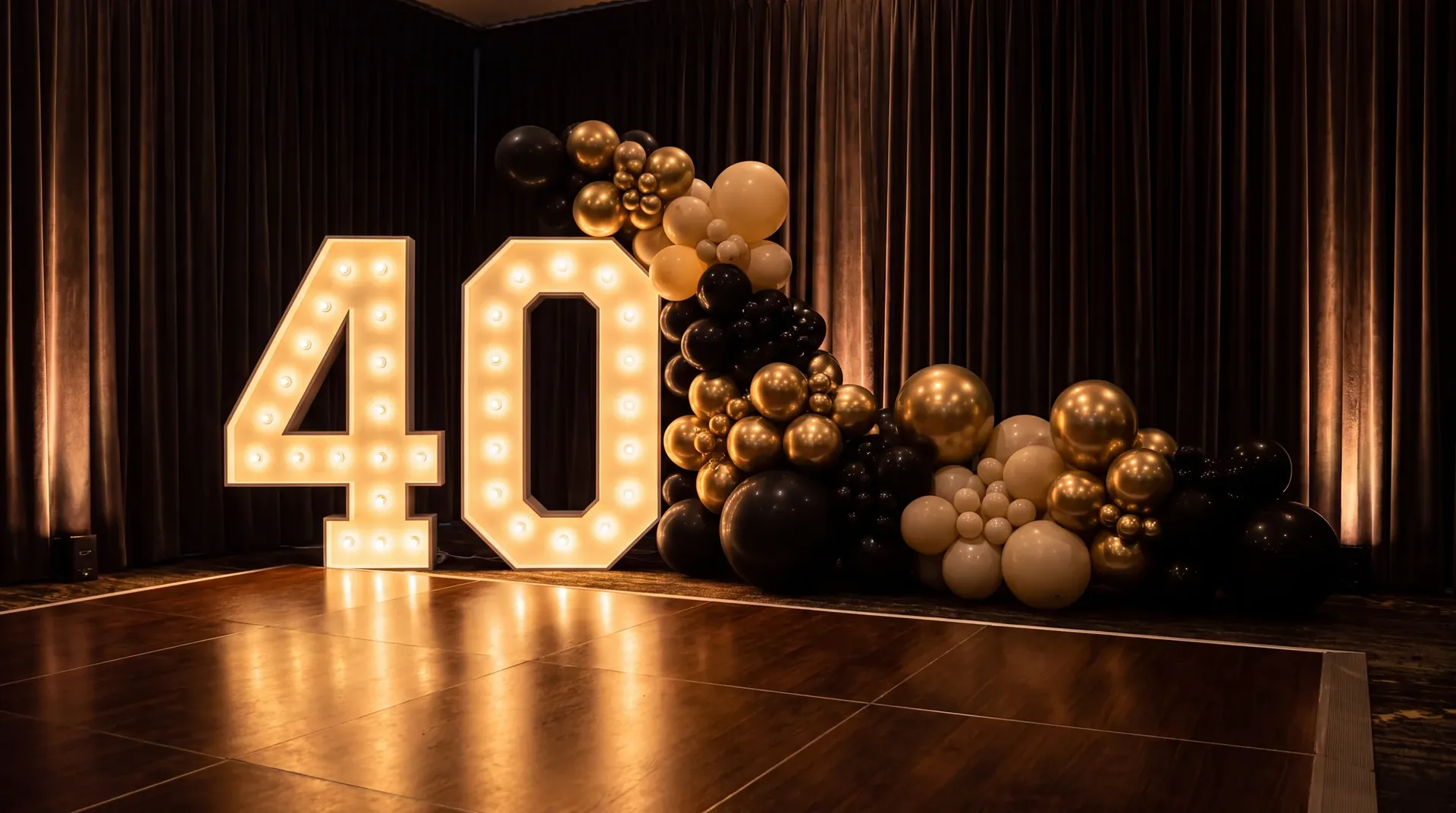 Illuminated marquee numbers beside a dense black, gold and ivory garland at night