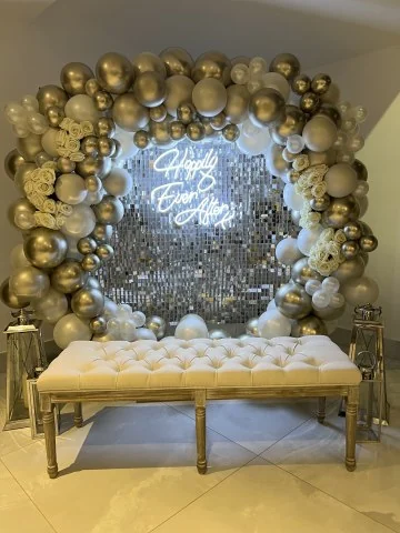 Mirrored sequin wall framed with a gold and ivory garland